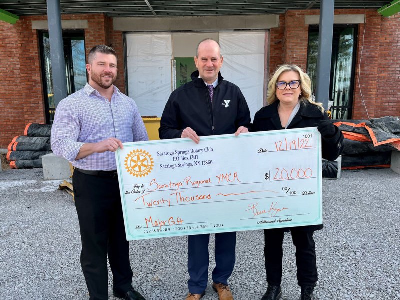 Rotary Club of Saratoga Springs’ President Stephen Kyne (left) and Major Gift Committee Chair Susan Rhoades (right), present their major gift to SRYMCA Chief Executive Officer Scott Clark (middle) at their Capital Project construction site. Photo provided. 