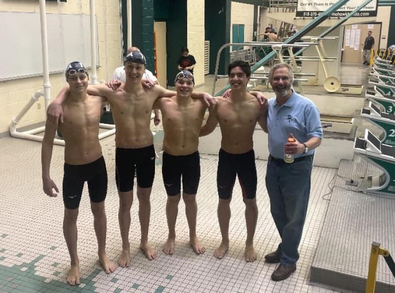 The Saratoga Springs boys’ varsity swim team poses with Coach William Asay. Photo provided by Elizabeth Baird.
