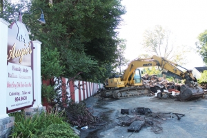 An excavator works on removing what was left of Augie’s after a Monday morning fire.