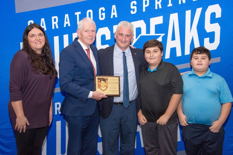 Blue Streak Athletic Hall of Fame committee member Matt Jones presents the plaque to Joey Santamoor and family