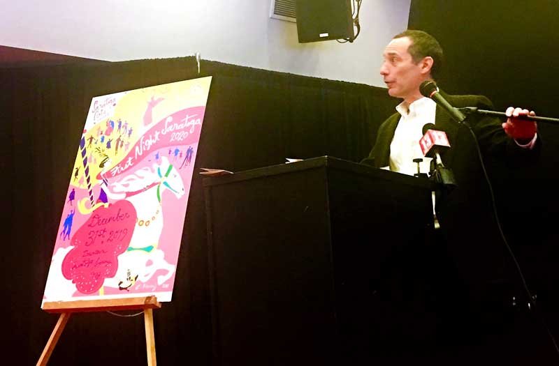 Joel Reed, executive director of Saratoga Arts, unveils First Night 2020 poster. Photo by Thomas Dimopoulos.