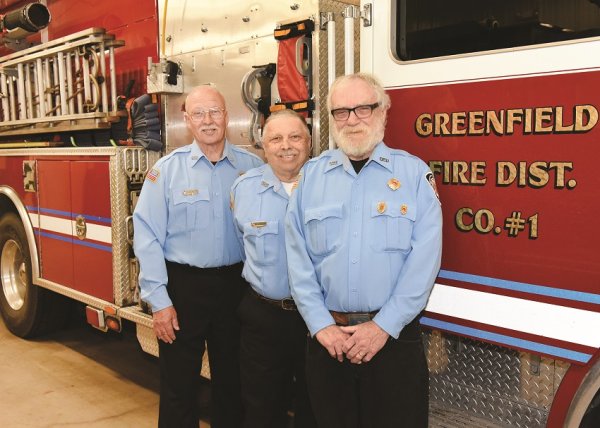 Volunteers for more than 50 years: Gordon McGrath, Robert Roxbury, and Jackie Atwell – posing for a photograph at the Greenfield Fire Station May 7, 2019 - will be recognized by the town of Greenfield for their service on Saturday. Photo by SuperSource Media. 
