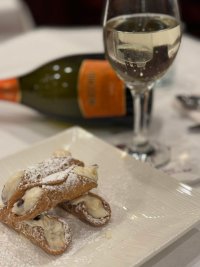 Free cannolis and glasses of Prosecco were offered to Augie’s Family Style Italian Restaurant patrons to celebrate the eatery’s 20th anniversary on Monday. Photo via the company’s Facebook page. 