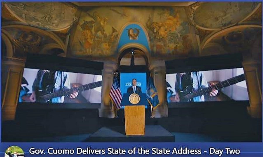Gov. Andrew State of The State address on Tuesday, framed by twin images of a bass guitar.