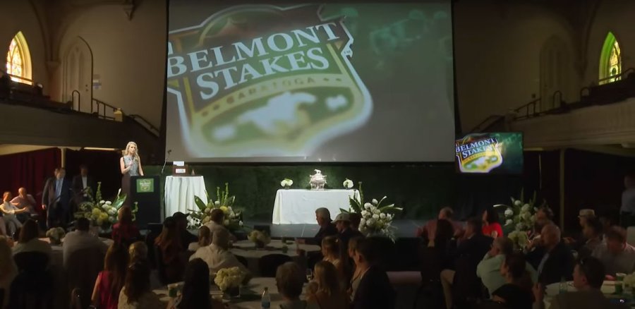 Fox Sports horse racing analyst Acacia Clement hosts the Belmont Draw Show at the Universal Preservation Hall in Saratoga Springs on Monday, June 3. Image via the New York Racing Association livestream of the event.