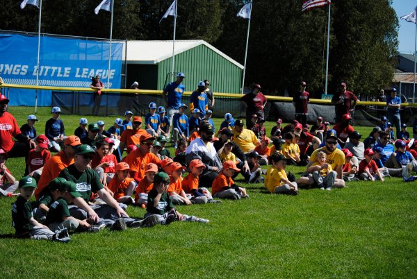 Players and coaches sit on the Majors Field during the Saratoga Springs Little League opening day ceremony on May 6.