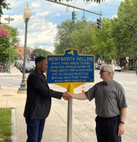 Saratoga Springs Department of Public Works Commissioner Jason Golub (left) and Bikeatoga Advocacy Chair Ed Lindner (right), unveil a new historical marker at 341 Broadway on June 26, 2024 celebrating Wentworth Rollins’ bike ride to Saratoga Springs in 1879. Photo by Thomas Dimopoulos. 